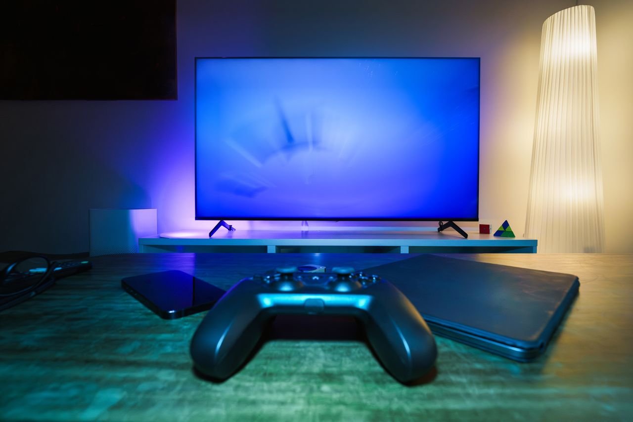 Crafting Captivating Headlines: Your awesome post title goes here A stylish and ambient gaming setup featuring a controller, smart devices, and a TV in a lit living room.